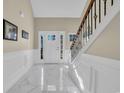 Bright foyer with marble tile floors, wainscoting, and a staircase with wood and iron railings at 224 Je Edward Dr. # 17, Myrtle Beach, SC 29588