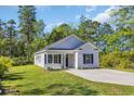 Attractive single-story home with light siding, dark shutters, and a spacious driveway at 3096 Hugo Rd., Conway, SC 29527