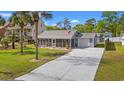 Beautiful home with a metal roof, an attached garage, and a long concrete driveway at 319 Sparrow Dr., Surfside Beach, SC 29575
