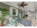 Cozy screened-in porch with rocking chairs and ceiling fans creating a relaxing outdoor space at 319 Sparrow Dr., Surfside Beach, SC 29575