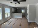 Bright living room featuring a ceiling fan, windows, and an open layout at 8058 Mill Pond Rd., Galivants Ferry, SC 29544
