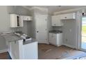 Cozy kitchen with white cabinets, granite countertops, and a breakfast bar, offering a modern and inviting space at 8062 Mill Pond Rd., Galivants Ferry, SC 29544