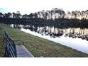 Relaxing pond view with a bench, mature trees, and reflected sunlight on a calm day at 897 Wild Leaf Loop, Conway, SC 29526