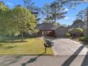 A well-maintained single-story home with a driveway, manicured lawn and mature trees at 111 Cedar Ridge Ln., Conway, SC 29526