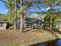 The rear exterior view of the home features a peaceful backyard, trees and waterfront at 111 Cedar Ridge Ln., Conway, SC 29526