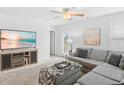 Bright living room with a comfortable sectional sofa, entertainment center with a large TV, and neutral carpeting at 115 Foxford Dr., Conway, SC 29526