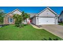 Charming single-Gathering home featuring a two-car garage, manicured lawn and inviting red door at 1154 Lampwick Ln., Murrells Inlet, SC 29576