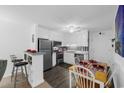 A well-lit kitchen with white cabinetry, stainless steel appliances, a dining table set for four, and nautical decor at 1919 Spring St. # 36A, North Myrtle Beach, SC 29582