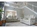Bright living room featuring high ceilings, staircase, and neutral-toned furniture at 2039 Chadbury Ln., Myrtle Beach, SC 29588