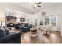 Inviting open-concept living room with hardwood floors, kitchen view and natural light from large windows at 230 Palmetto Green Dr., Longs, SC 29568