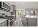 Open kitchen showcasing stainless steel appliances and gray cabinets at 419 Lifestyle Court, Surfside Beach, SC 29575