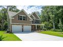 Side view of a tan and stone accented two-story home with a two-car garage and well-maintained lawn at 443 Clear Lake Dr., Conway, SC 29526