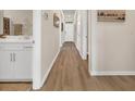 Open hallway with wood floors, leading to a bright bathroom and white front door at 500 Honeyhill Loop, Conway, SC 29526