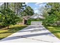 Charming single-story home with a well-maintained lawn and attached two-car garage with verdant foliage at 2934 Midiron Ct., Myrtle Beach, SC 29577