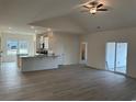 Spacious living area with hard wood floors, stainless appliances, kitchen island, and glass sliding door at 553 Honeyhill Loop, Conway, SC 29526