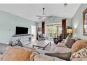 A cozy living room offering a neutral color palette, plush sectional sofa, a ceiling fan, and access to the outdoor balcony at 5750 Oyster Catcher Dr. # 1135, North Myrtle Beach, SC 29582