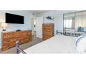 Bright bedroom featuring a comfortable bed, wooden dressers, and mirrored closet doors at 6100 N Ocean Blvd. # 804, North Myrtle Beach, SC 29582