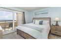 Cozy bedroom features a balcony with ocean views and neutral decor creating a serene and relaxing space at 6100 N Ocean Blvd. # 804, North Myrtle Beach, SC 29582
