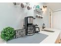Coffee station featuring a coffee maker, sink, and a charming sign at 6100 N Ocean Blvd. # 804, North Myrtle Beach, SC 29582