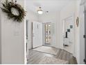 Charming foyer with decorative wreath, neutral paint, hard wood floors, and screened front door at 948 Jackline Place # 201, Murrells Inlet, SC 29576