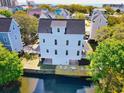 Stunning aerial view of a coastal home with a private deck and serene waterway views at 108 Tidal Creek Dr., Garden City Beach, SC 29576