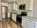 Modern kitchen features stainless steel appliances, granite countertops, and white cabinets at 1516 Saint George Ln., Myrtle Beach, SC 29588