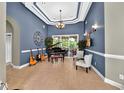 Elegant living room with stylish blue walls, a piano, and ample natural light at 4016 Atalaya Pl., Myrtle Beach, SC 29579