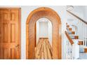 Unique wood archway and beautiful wood-look flooring in a well-lit hallway with a staircase and wooden doors at 4240 Highway 17 Business, Murrells Inlet, SC 29576