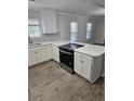 Bright kitchen with stainless steel appliances, white cabinets, quartz countertops and luxury vinyl flooring at 501 Hillside Dr. N, North Myrtle Beach, SC 29582