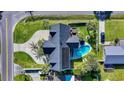 Aerial view of a landscaped property with a pool, hot tub, fire pit, patio, and lush green lawn at 811 10Th Ave. S, Surfside Beach, SC 29575