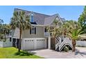 Exterior elevation of a two-story home with a two-car garage and palm tree landscaping in the front yard at 811 10Th Ave. S, Surfside Beach, SC 29575