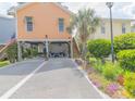Inviting raised beach home featuring well manicured landscaping and an extended driveway at 93 Weatherboard Ct., Pawleys Island, SC 29585