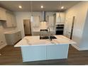 Modern kitchen featuring a large island with quartz countertops, stainless steel appliances, and white cabinets at 1059 Laconic Dr., Myrtle Beach, SC 29588