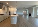 Open-concept kitchen flowing into the living room, featuring a large island, fireplace, and wood-look floors at 1059 Laconic Dr., Myrtle Beach, SC 29588
