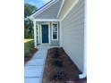Inviting front porch with a blue door and a well-maintained landscaped garden at 1237 Lady Bird Way, North Myrtle Beach, SC 29582