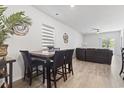 Open-concept living room boasts stylish table with four chairs and a cozy brown couch near sliding glass doors at 148 S Reindeer Rd., Surfside Beach, SC 29575