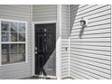 Close-up of front door entrance with sidelight window, black door, and matching outdoor light fixture at 155 Westhaven Dr. # 14D, Myrtle Beach, SC 29579