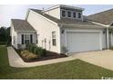 Charming single-story home featuring a two-car garage and nicely landscaped front yard at 1835 Berkley Village Loop, Myrtle Beach, SC 29579