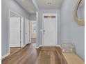 Bright entryway featuring wood floors, a white front door, and a cozy bench near the mirror accent at 2771 Eclipse Dr., Myrtle Beach, SC 29577