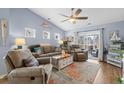 Comfortable living room features a ceiling fan and sliding glass doors leading to a patio at 328 Logan St., Little River, SC 29566