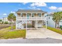 Inviting two-story beach house featuring a large front porch, parking, and covered outdoor space at 6302 Nixon St., North Myrtle Beach, SC 29582