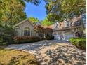 Charming brick home featuring an attached garage, well-manicured lawn, and mature shade trees at 710 Masters Dr., Pawleys Island, SC 29585