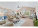 Bright living room featuring a ceiling fan, neutral colors, and comfortable seating with large windows at 10 Logan Berry Ct. # H, Murrells Inlet, SC 29576
