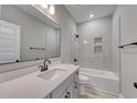 Well-lit bathroom with a tub-shower combo, large mirror, and gray tile at 1063 Laconic Dr., Myrtle Beach, SC 29588