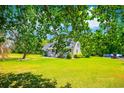 Exterior view of home with green grass visible between trees at 2400 Bay View Dr., Green Sea, SC 29545