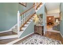 Inviting foyer with a staircase, hardwood floors, a decorative rug, and a view into the living room with a fireplace at 124 Windmeadows Dr., Conway, SC 29526