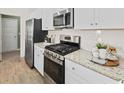 Modern kitchen featuring granite countertops, stainless steel appliances and white cabinets at 135 Warner Crossing Way, Loris, SC 29569