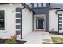 Up-close view of the black front door with decorative accents and modern white and black trim at 1559 Old Tram Rd., Little River, SC 29566