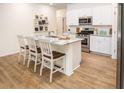 Stylish kitchen featuring white cabinets, stainless steel appliances, granite countertops, and a central island with seating at 166 Waterloo Sunset Dr., Longs, SC 29568