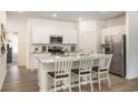 Modern kitchen with white cabinetry, granite countertops, stainless appliances, and a center island with bar stool seating at 166 Waterloo Sunset Dr., Longs, SC 29568